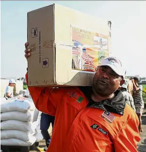  ?? — Bernama ?? Giving a hand: Organising committee head Datuk Seri Abdul Azeez Abdul Rahim carrying a box of supplies for the Rohingya.