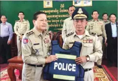  ?? SUPPLIED ?? National Police Chief Neth Savoeun (left) instates Lao Sokha, the former Kandal deputy provincial police chief, in his new role as provincial police chief in Mondulkiri yesterday.