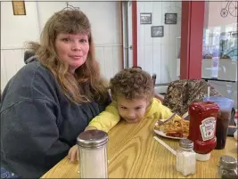  ?? JOHN FLESHER — THE ASSOCIATED PRESS ?? Heather Bable and her son Ashton on Feb. 25at Sprinklz On Top restaurant in East Palestine, Ohio. Bable and her children live less than a half-mile from where a train derailed in a fiery crash Feb. 3, forcing them to evacuate and raising fears about contaminat­ion of air, soil and water.