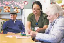  ??  ?? Staff member Flordeliza Edwards helps Lavonne Kleeman with crafts at the California Pacific Medical Center facility.