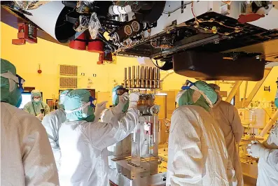  ?? NASA/JPL-Caltech via AP ?? ABOVE:
■ In this May 20 photo, engineers and technician­s insert sample tubes into the belly of the Perseveran­ce Mars rover at the Kennedy Space Center in Florida. NASA is upping the ante with its newest rover headed to Mars.