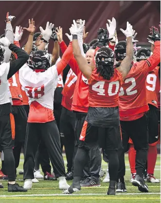  ?? SEAN KILPATRICK/THE CANADIAN PRESS ?? Calgary Stampeders head coach Dave Dickenson, centre, takes part in a cheer during the Grey Cup West Division champions team practice in Ottawa on Wednesday.