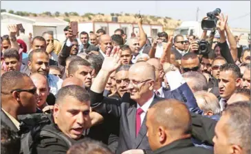  ?? MAHMUD HAMS/AFP ?? Palestinia­n Prime Minister Rami Hamdallah (centre) is surrounded by security as he waves following his arrival at the Erez border crossing in Beit Hanun, in the northern Gaza Strip, yesterday.