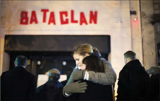  ?? (File Photo/AP/Thibault Camus) ?? Women hug Nov. 13, 2016, in front of the Bataclan concert hall in Paris.