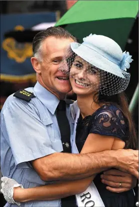  ??  ?? Wexford Rose Sarah-Mai Fitzpatric­k has a hug for her dad Pat, who is a member of the Gardai Band, at the Parade of Roses which is part of the Rose of Tralee Festival in Co Kerry.