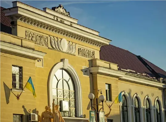  ?? Stephen Zenner/The Blade photos ?? Tape is applied to the glass windows at the train station in Mukachevo, Ukraine, in case a bomb shatters them.