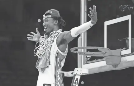  ?? BILL STREICHER/USA TODAY SPORTS ?? North Carolina guard Leaky Black cuts down the net after the Tar Heels defeated Saint Peter’s in the final of the NCAA Tournament’s East Regional at Wells Fargo Center in Philadelph­ia on March 27.