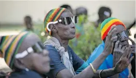  ?? Moran Eye Center ?? A woman from the Dinka tribe sings and dances with members of the Nuer tribe in December 2012 after their sight was restored by American eye surgeons
in the village of Duk Payuel in South Sudan’s Jonglei state.