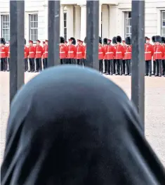  ??  ?? A question of headgear: watching Guards on parade at Wellington Barracks, London