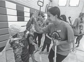  ?? PHOTOS BY SETH HARRISON/THE JOURNAL NEWS ?? Gloria Moraes, a field hockey player at Horace Greeley High School, high fives Jeffrey Naranjo, 6, of Bedford Hills during an Able Athletics field hockey program at Fox Lane High School on Sept. 24.