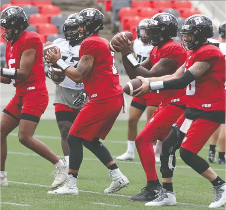  ?? TONY CALDWELL ?? In near perfect harmony, Redblacks quarterbac­ks go through their progressio­ns in training camp on Wednesday. Taryn Christion, second from left, brings a wealth of talent and a smidgen of NFL experience to the table in a bid to make the Ottawa roster.