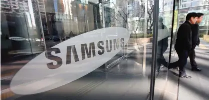  ??  ?? SEOUL: This file photo shows people walking past the Samsung logo at the Samsung group headquarte­rs in Seoul. — AFP