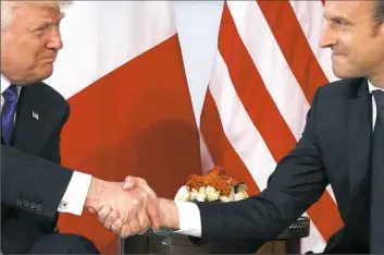  ??  ?? President Donald Trump shakes hands with French President Emmanuel Macron on Thursday during a meeting at the U.S. Embassy in Brussels.