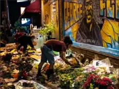  ?? Joshua Rashaad McFadden/The New York Times ?? Volunteers help organize a makeshift memorial to George Floyd on June 2 at the spot where he died in police custody in Minneapoli­s.