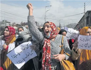  ?? AFP ?? Pakistani women married to former Kashmiri militants shout slogans and hold placards during a protest urging Indian and Pakistani prime ministers to facilitate their return to Pakistan in Srinagar on Tuesday.
