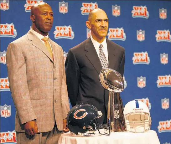  ?? JIM PRISCHING/CHICAGO TRIBUNE ?? Super Bowl coaches Lovie Smith (with the Chicago Bears) and Tony Dungy (with the Indianapol­is Colts) pose with the Lombardi Trophy on Feb. 2, 2007.