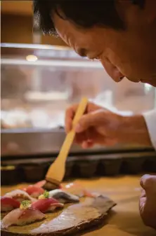  ?? John Storey / Special to The Chronicle 2014 ?? Chef Ken Tominaga, who developed his love for the culinary world at a young age, prepares sushi at Pabu in S.F. in 2014.