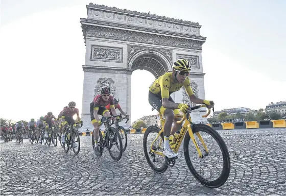  ??  ?? ABOVE
Egan Bernal, right, rides past the Arc de Triomphe on the Champs Elysees on his way to winning the Tour de France last Sunday.