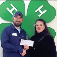  ?? Contribute­d ?? Catoosa County 4-H Agent Caleb Millican receives a Smith Charitable Endowment donation from Krista Smith Autry for its summer camp program.