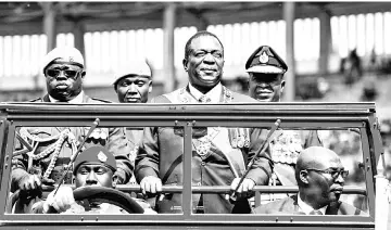  ??  ?? Mnangagwa (centre) inspects the guard of honour from a car during the Defence Forces Day celebratio­ns held at the National Sports Stadium in Harare. — AFP photo