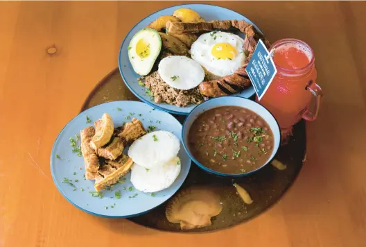  ?? BILLY SCHUERMAN/THE VIRGINIAN-PILOT PHOTOS ?? Chicharron (pork rind) with Ensalada de la Casa (salad); main dish, Bandeja Paisa (rice, beans, egg, beef, avocado and Colombian sausage); and the drink, Limonada Cerezada at Rosa Colombian Bar and Grill in Newport News.