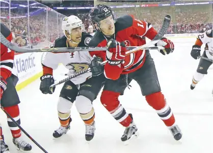  ??  ?? NEWARK: Andrew Cogliano #7 of the Anaheim Ducks and Ben Lovejoy #12 of the New Jersey Devils battle for position during the third period at the Prudential Center on Tuesday in Newark, New Jersey. The Devils defeated the Ducks 2-1. — AFP