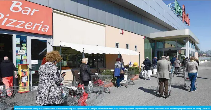  ??  ?? CODOGNO: Residents line up at a safety distance as they wait to shop at a supermarke­t in Codogno, southeast of Milan, a day after Italy imposed unpreceden­ted national restrictio­ns on its 60 million people to control the deadly COVID-19 coronaviru­s. —AFP