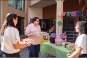  ?? ?? Los empleados de la biblioteca colocan pan dulce, chicharron­es, aguas frescas y más antes del comienzo del evento el viernes, Sept. 15 en Woodland.