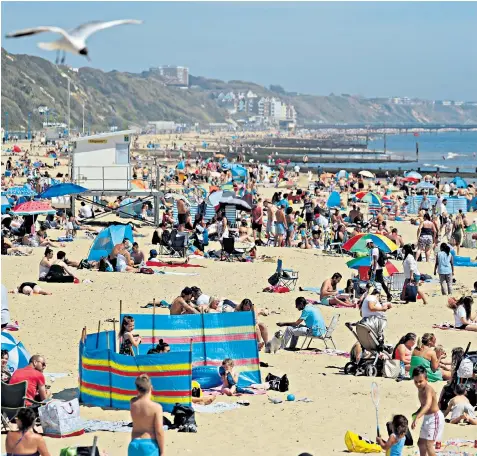  ??  ?? The two-metre social distancing rule was tested on Bournemout­h beach yesterday as day-trippers took advantage of the sunshine and the relaxation in lockdown rules