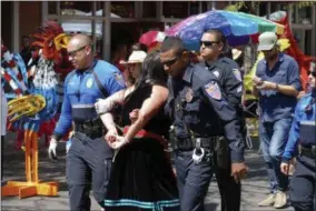  ?? MORGAN LEE — THE ASSOCIATED PRESS ?? Police in Santa Fe, N.M., lead away protester organizer Jennifer Marley of San Ildefonso Pueblo in hand restraints on Friday, Sept. 8, 2017. Santa Fe police say they arrested at least 12people to contain a protest against an annual pageant marking the...