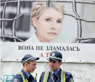  ?? (Afp) ?? Kiev Agenti davanti a un poster con il volto della 52enne Yulia Tymoshenko: «Lei non si piega e tu?»