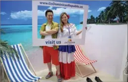  ?? CHEN XIAOGEN / FOR CHINA DAILY ?? A visitor (left) takes a photo with an exhibition staff member at a recent internatio­nal tourism expo in
