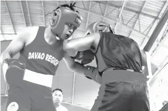  ?? MARK A. PERANDOS ?? LONE SURVIVOR. Paul Julyfer Celis Bascon unleashes a left hook against Romel Bale of Soccsksarg­en enroute to winning Davao region's lone boxing gold medal in college men's middleweig­ht event at the Almendras Gym Davao City Recreation Center late Wednesday afternoon.