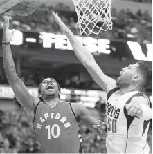  ?? THE ASSOCIATED PRESS ?? Toronto guard DeMar DeRozan, left, attempts a layup as Dallas forward Salah Mejri defends.