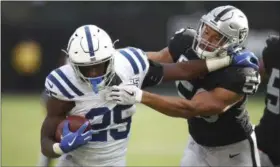  ?? BEN MARGOT, FILE — THE ASSOCIATED PRESS ?? Indianapol­is Colts running back Marlon Mack (25) tries to fend off Oakland Raiders linebacker Kyle Wilber (58) during the second half of an NFL football game in Oakland, Calif. Last week, Mack became Indy’s first back with consecutiv­e 100-yard games since Joseph Addai in 2007.