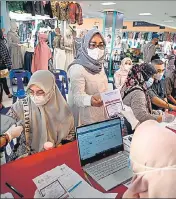  ??  ?? People queue to receive a dose of the Sinovac coronaviru­s vaccine at a shopping centre in Banda Aceh, Indonesia.