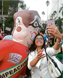  ?? Fotos Danilo Verpa/Folhapress ?? Mulher faz selfie com boneco de Dilma em ato na quarta (16)