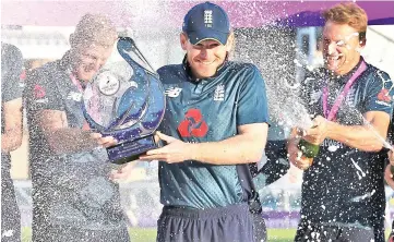  ??  ?? England’s players spray champagne as captain Eoin Morgan (centre) holds the series trophy after the third One Day Internatio­nal (ODI) cricket match between England and India, at Headingley Stadium in Leeds, northern England. — AFP photo