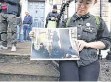  ??  ?? Not correct: An activist at 34 North Frederick Street holds a picture showing an eviction with hooded gardaí present