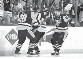  ?? Jamie Sabau Getty Images ?? CHRIS KUNITZ, center, reaps kudos from Sidney Crosby, right, and Ian Cole after his winning goal in a marathon Game 7 in the Eastern Conference finals.