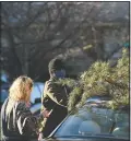  ??  ?? Parker Vivier and Marsden Olsen, both of Richmond, tie their tree to their car.