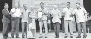  ??  ?? ASSAFAL (empat dari kanan) menyampaik­an anugerah kepada Guru Besar SMK Tawau sebagai johan Wira Serasi.