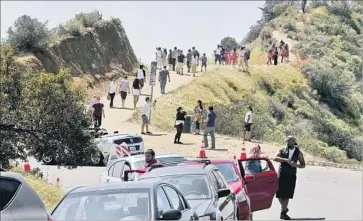  ?? Allen J. Schaben Los Angeles Times ?? TOURISTS ON Mt. Hollywood Drive hike toward the Hollywood sign. A gondola could come from the Universal Studios area and generate revenue to relieve traffic and improve Griffith Park, the mayor suggests.