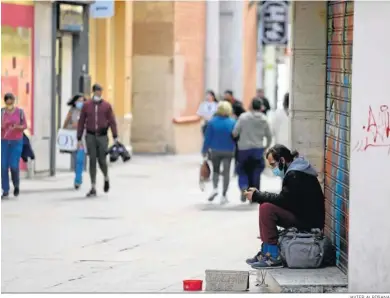  ?? JAVIER ALBIÑANA ?? Un hombre pide en una calle de Málaga.