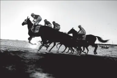  ?? JON NAZCA / REUTERS ?? The beach of Sanlucar de Barrameda, in the Spanish province of Cadiz, is an unusual location for horse racing. But every August, dating back to 1845, the pounding of hooves has been a feature, tide permitting.