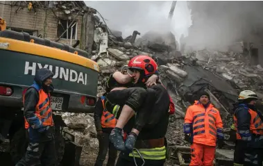  ?? ?? Emergency teams worked through the night to pull survivors from the rubble of the multi- storey building in Dnipro