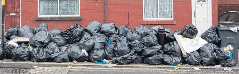  ??  ?? Piles of black rubbish bags block the pavements in Small Heath, Birmingham, as the strike by binmen enters its fifth week