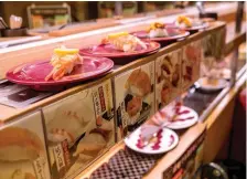  ?? — AFP photo ?? Photo shows plates of sushi on a conveyor belt at a sushi chain restaurant in Tokyo.