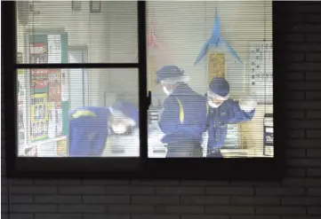  ??  ?? Police inspect the office where a policeman was shot dead in western Japan’s Hikone, Shiga prefecture. — AFP photos