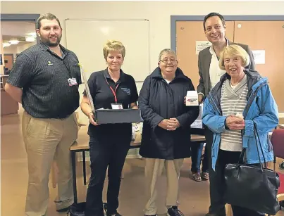  ??  ?? Liam Kerr MSP, right, with service users and volunteers during a visit to Hear to Help in Forfar.